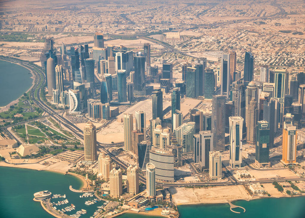 Widok z lotu z samolotu na dauhańską panoramę. Korniszowe i nowoczesne budynki, Katar. - Zdjęcie, obraz