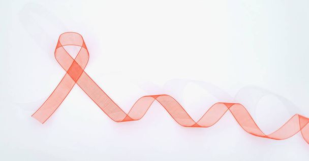 Nahaufnahme rotes Band Bewusstsein auf weißem Hintergrund für die Welt-Aids-Tag-Kampagne. Gesundheits- und Medizinkonzept. - Foto, Bild