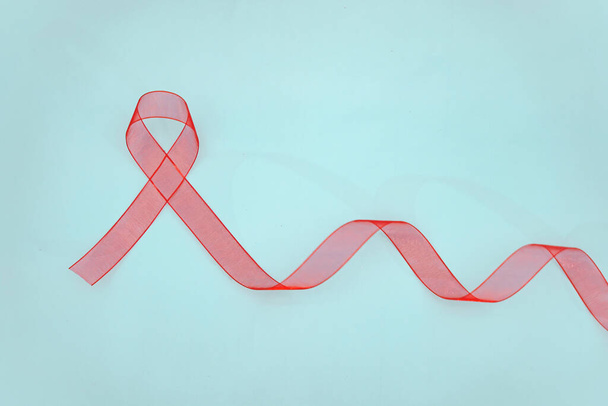 Nahaufnahme rotes Band Bewusstsein auf weißem Hintergrund für die Welt-Aids-Tag-Kampagne. Gesundheits- und Medizinkonzept. - Foto, Bild