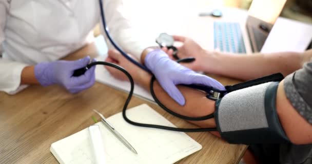 Il medico nella clinica misura la pressione di una persona, mani primo piano. Apparecchiature mediche per il monitoraggio della pressione sanguigna - Filmati, video