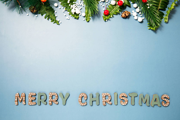 青い背景にモミの木の枝や雪とクリスマスの装飾 - 写真・画像