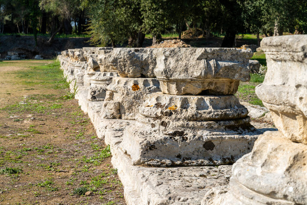 Olympia, Grecja- 11 listopada 2022 r.: widok z bliska na niskie kąty starych baz kolumnowych w Palestynie w Starożytnej Olimpii - Zdjęcie, obraz
