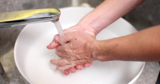 Egy férfi kezet mos a víz nyomása alatt, közelről. Higiéniai eljárás, modern vízvezeték-szerelés - Felvétel, videó
