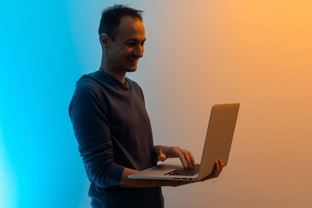 Portrait of his he nice attractive cheerful cheery successful content smart clever brunet guy agent broker holding in hands laptop working isolated over color background. - Photo, Image