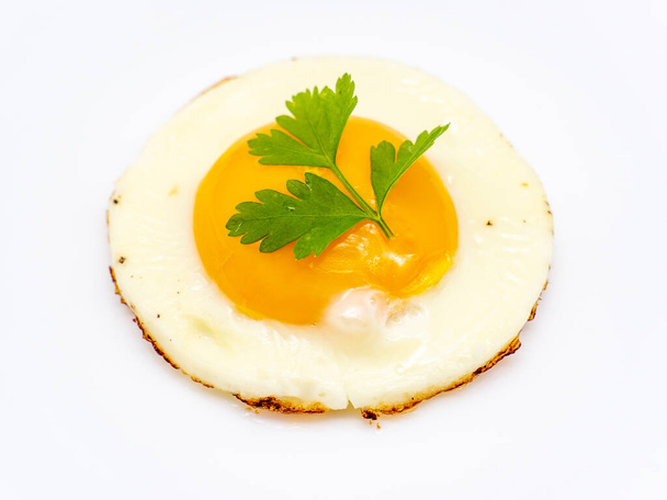 Maydanozla süslenmiş bir tabakta sahanda yumurta - Fotoğraf, Görsel