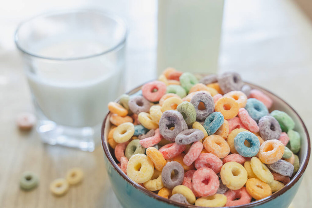 Bowl of colorful children's cereal and milk isolated on wood table with Text space - Foto, Bild