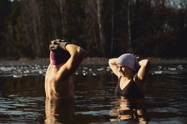 Kaukázusi pár úszik a befagyott tóban  - Fotó, kép