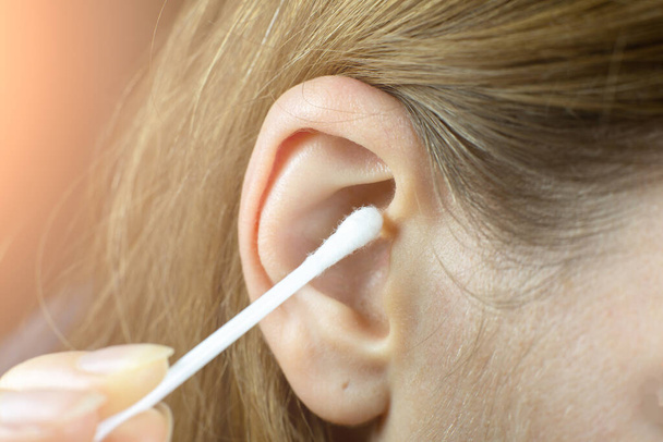 Закрывай, женщина использует тампоны из уха. Гигиенические палки для ушей. - Фото, изображение