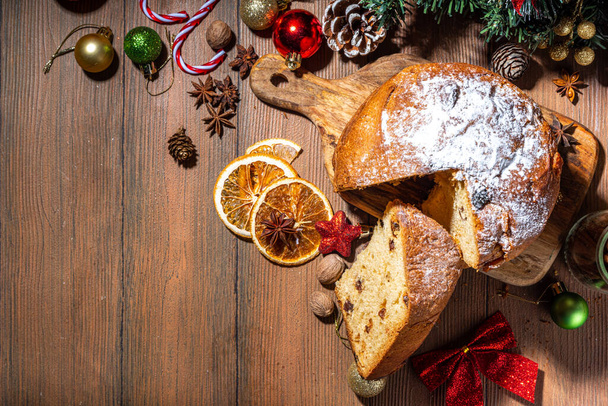 Pastel tradicional de Navidad panettone con frutas secas, especias, árbol de Navidad y decoración sobre fondo rústico de madera  - Foto, imagen