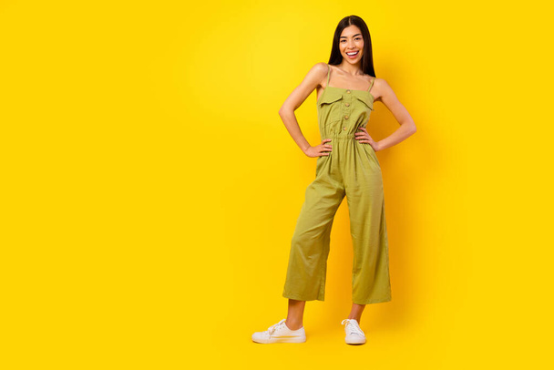 Full body photo of adorable cheerful malaysian person put arms waist posing isolated on yellow color background. - Φωτογραφία, εικόνα
