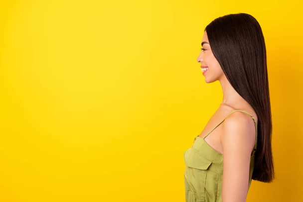 Profile photo of cheerful gorgeous malaysian lady look empty space beaming smile isolated on yellow color background. - Fotoğraf, Görsel