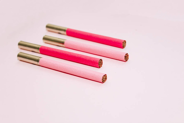 Cigarrillos multicolores sobre un fondo de papel, el concepto de un mal hábito. - Foto, Imagen