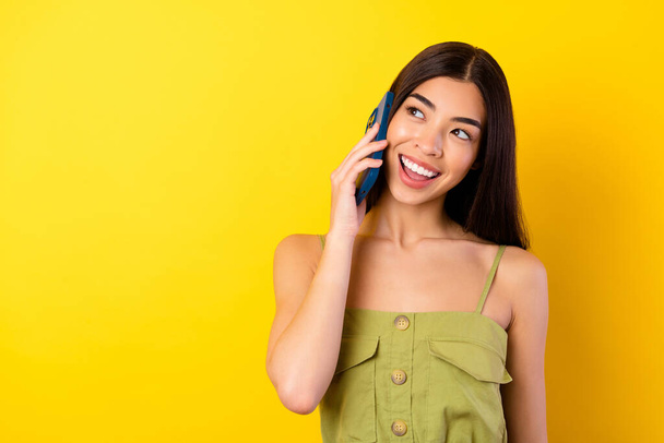 Photo of cute positive filipino person speak communicate telephone isolated on yellow color background. - Φωτογραφία, εικόνα