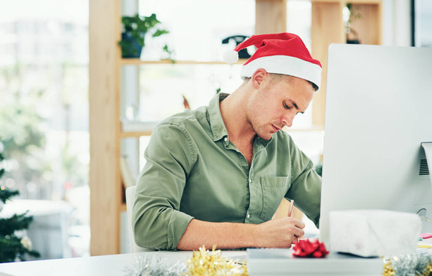 Noel, bilgisayar ve iş adamı bir masada yazıyor, sadece ofisinde düşünüyor ve planlıyor. Noel arifesinde son teslim tarihine yetişmeye çalışan şenlikli, sezonluk ve çalışanlar, liste, not ya da hatırlatma. - Fotoğraf, Görsel