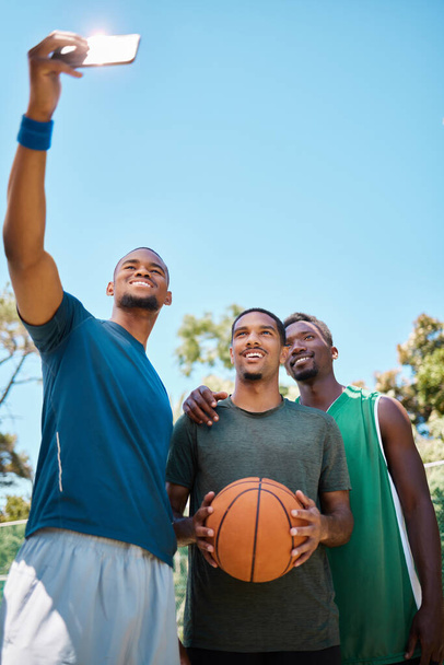 Selfie, basquete e equipe com telefone na quadra no jogo, treinamento ou prática. Atletas de fitness, esportes e africanos tirando fotos para mídias sociais em quadra de basquete após jogo com espaço de mockup - Foto, Imagem