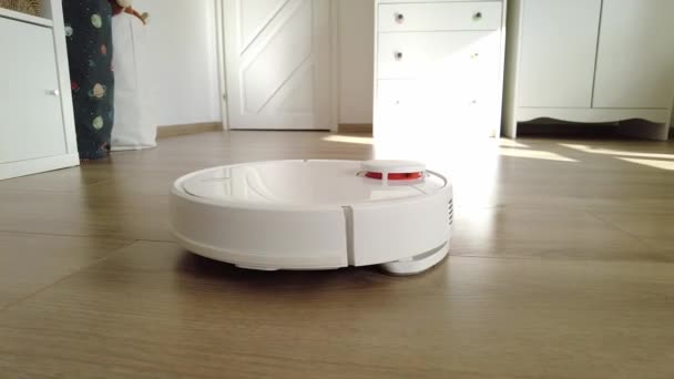 Robot de vacío de limpieza en casa. Robot aspiradora en el hogar moderno. Tecnología de limpieza inteligente - Imágenes, Vídeo