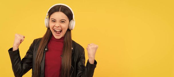 listen to music. wireless headset device accessory. new technology. Child portrait with headphones, horizontal poster. Girl listening to music, banner with copy space - Foto, Imagen