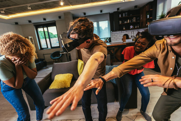 Felices amigos divirtiéndose con VR en el interior del hogar - Foto, imagen