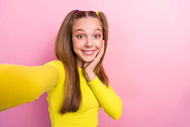 Photo of positive good mood girl straight hairstyle wear yellow top doing selfie palm on cheekbone isolated on yellow color background. - Foto, immagini