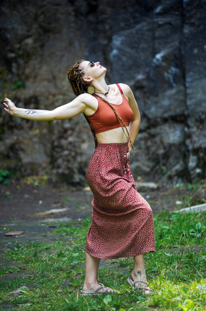 Beautiful girl with dreadlocks, dressed hippie style,poses outdoors. - 写真・画像