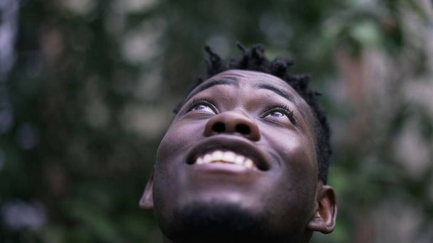 Young African man face close-up looking up with HOPE and FAITH - Φωτογραφία, εικόνα