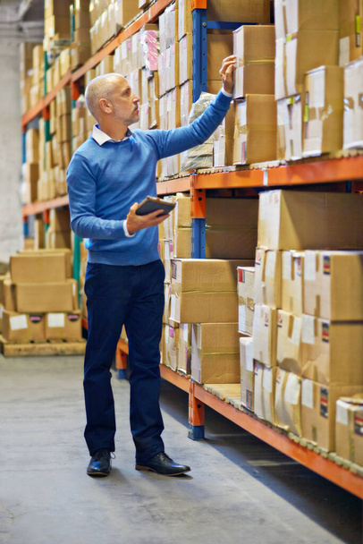 Accuracy is paramount. An employee doing an inventory check in a warehouse - Photo, Image