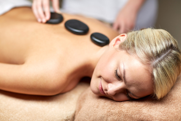 close up of woman having hot stone massage in spa - Foto, Imagen