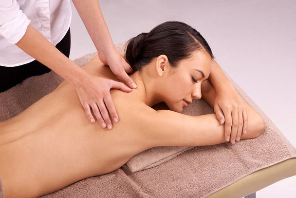 Stress be gone. a beautiful young woman enjoying a relaxing massage - 写真・画像