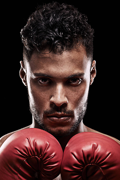 Know yourself and you will win all battles. Portrait of a young man wearing boxing gloves against a black background - Foto, Imagem
