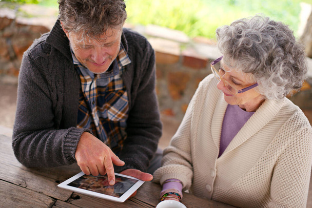 Nigdy nie jest za stary, by uczyć się nowych rzeczy. Duże ujęcie pary seniorów korzystającej z tabletu cyfrowego - Zdjęcie, obraz