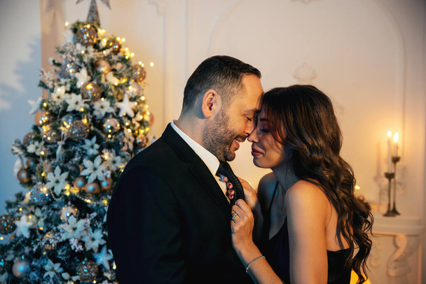 Portrait of a 30s elegant and lovely couple preparing for christmas party - Foto, afbeelding