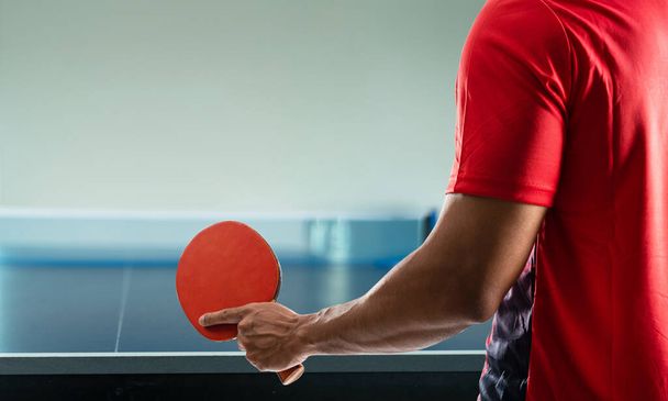 fiatal sportoló játszik ping-pong elszántsággal győzelem játszik fehér háttér. - Fotó, kép