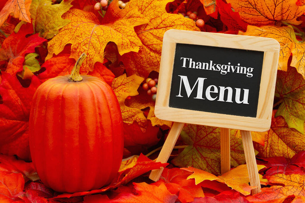 Thanksgiving menu on a chalkboard with fall leaves and a pumpkin - Photo, Image