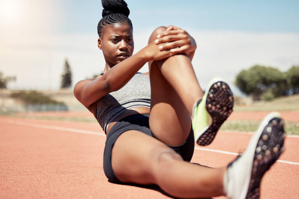 Černá žena, běžec protahování a trénink pro závod na závodní dráze na stadionu se zaměřením, odhodlání a motivace. Venkovní fitness tělocvik, běh sportovní cvičení a atlet protahování na podlaze. - Fotografie, Obrázek