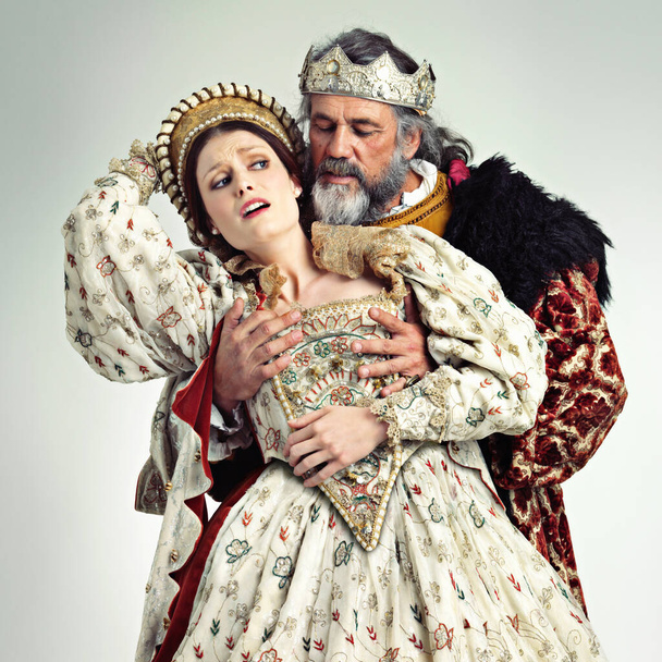 The king gets what he wants. Studio shot of a king ravishing his queen against her will - Photo, Image