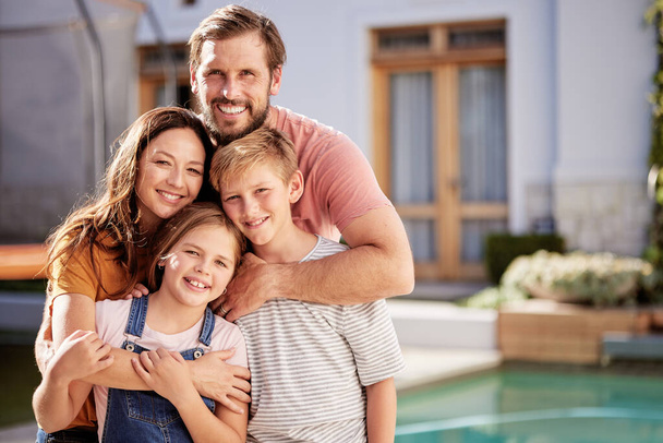 Happy family, relax outside house and portrait with children, mom and dad smile with love by pool together. Outdoor of mother, father and young kids hug together outside a modern home summer bonding. - Zdjęcie, obraz