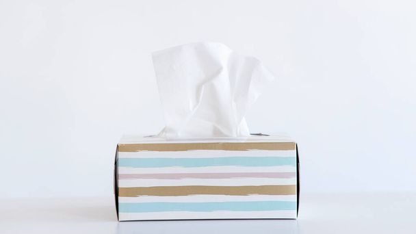 Jasny kolor serwetka chusteczka pudełko na białym tle. Koncepcja przeziębienia i grypy. - Zdjęcie, obraz