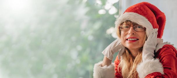 Erwachsene Frau mittleren Alters im Weihnachtsmann-Kostüm - Foto, Bild