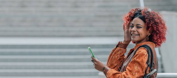 afro americká latinská dívka s mobilním telefonem na ulici na podzim - Fotografie, Obrázek