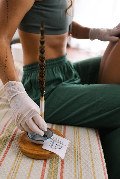 Деталь татуировки Handpoke, ручная заправка иглы новыми чернилами для татуировки - Фото, изображение