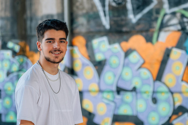 jovem milenar urbano na rua com parede com graffiti - Foto, Imagem