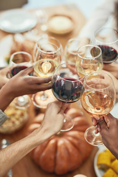 Wine, cheers and glasses at christmas toast, holiday celebration with food, friends and family together. Hands, wine glasses and friendship, celebrate diversity at dinner party with men and women - Foto, Imagem