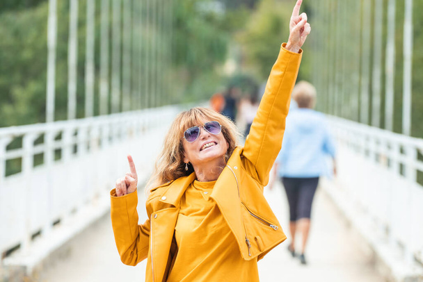 жінка середнього віку на відкритому повітрі з щасливим виразом
 - Фото, зображення