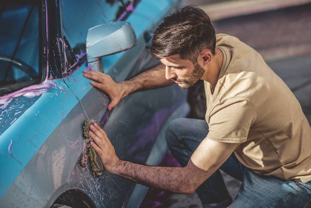 Trabalhador de serviço de carro profissional limpando o exterior de um veículo a motor com uma esponja de microfibra - Foto, Imagem