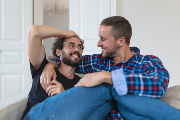 Milující stejný pohlaví muž gayové pár ležící na pohovce doma a relaxující, mazlící se spolu - Fotografie, Obrázek