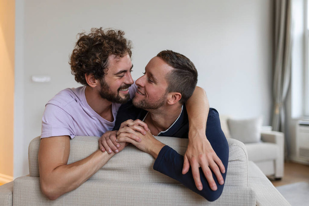 Щаслива гомосексуальна пара лежить на ліжку вдома, обіймає і фліртує. ЛГБТ гей-пара любовні моменти концепція щастя
 - Фото, зображення