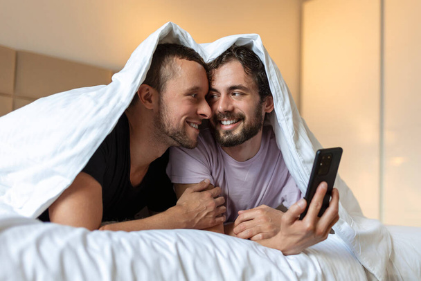 gelukkig gay paar having teder momenten in slaapkamer - homoseksuele liefde relatie en gender gelijkheid concept - Foto, afbeelding