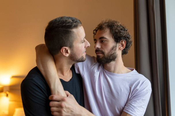 Two young man lgbtq gay couple dating in love hugging enjoying intimate tender sensual moment together kissing with eyes closed - Фото, изображение