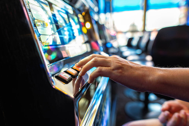 Κλείσιμο του Gambler Πατώντας το κουμπί Spin ενώ παίζετε Κουλοχέρη στο Καζίνο. Θέμα βιομηχανίας τυχερών παιχνιδιών. - Φωτογραφία, εικόνα