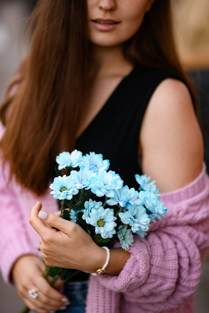 selective focus on bunch of beautiful blue chrysanthemum flowers in the hands of woman. Close-up view - 写真・画像